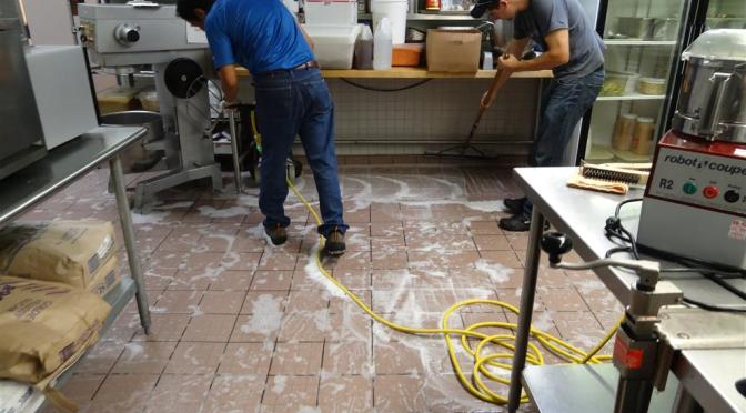 commercial kitchen cleaning Moncton NB — AA Cleaning Solutions team scrubbing restaurant kitchen floor